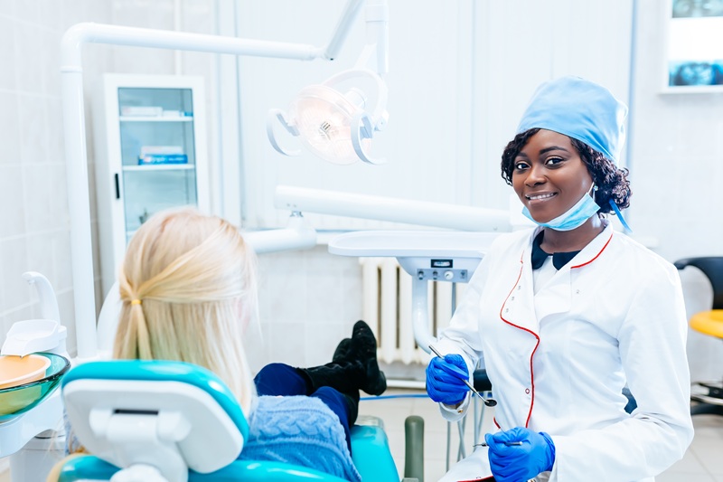 African american female dentist treating patient at clinic. Dental clinic concept.